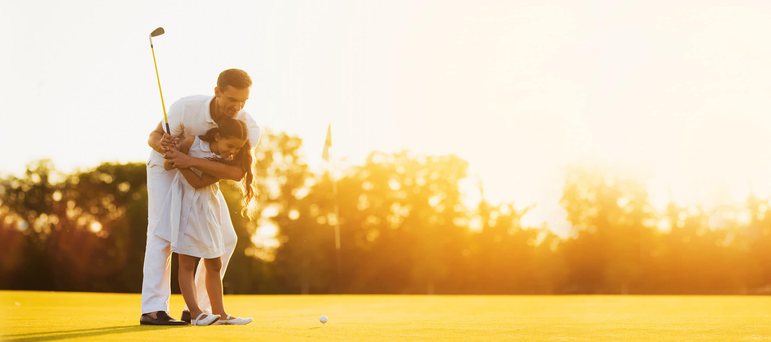Parent teaching a child to play golf at sunset, representing how private jet charter gives business leaders more time for family, relationships, and the moments that matter most.