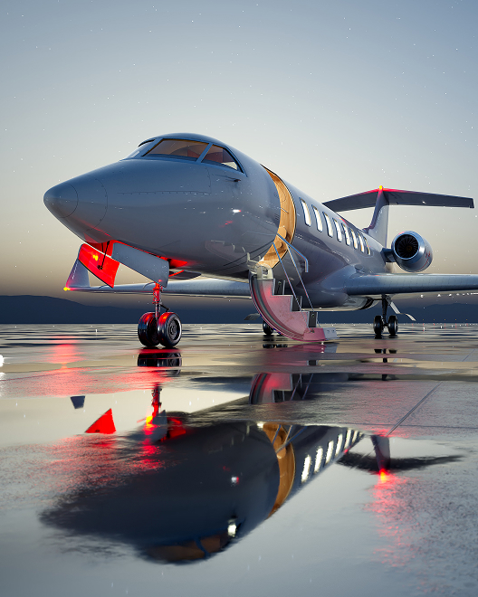 Private jet parked on an airport ramp at twilight with the cabin door open and lights reflecting across wet pavement, representing the flexibility and efficiency of fractional aircraft ownership.