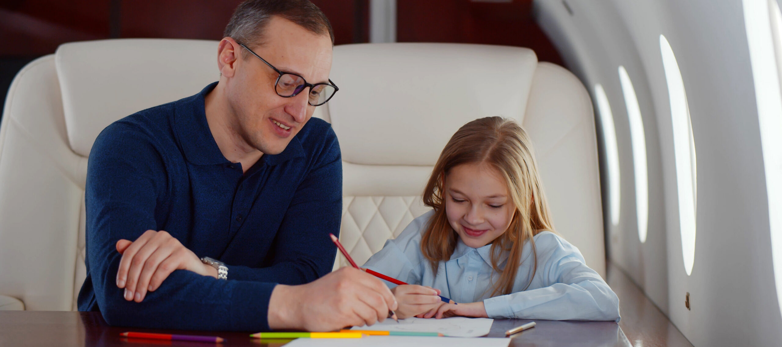 Parent and child spending quality time together inside a private jet cabin, representing the family time, travel convenience, and personalized experience of a private jet charter membership for frequent travelers.