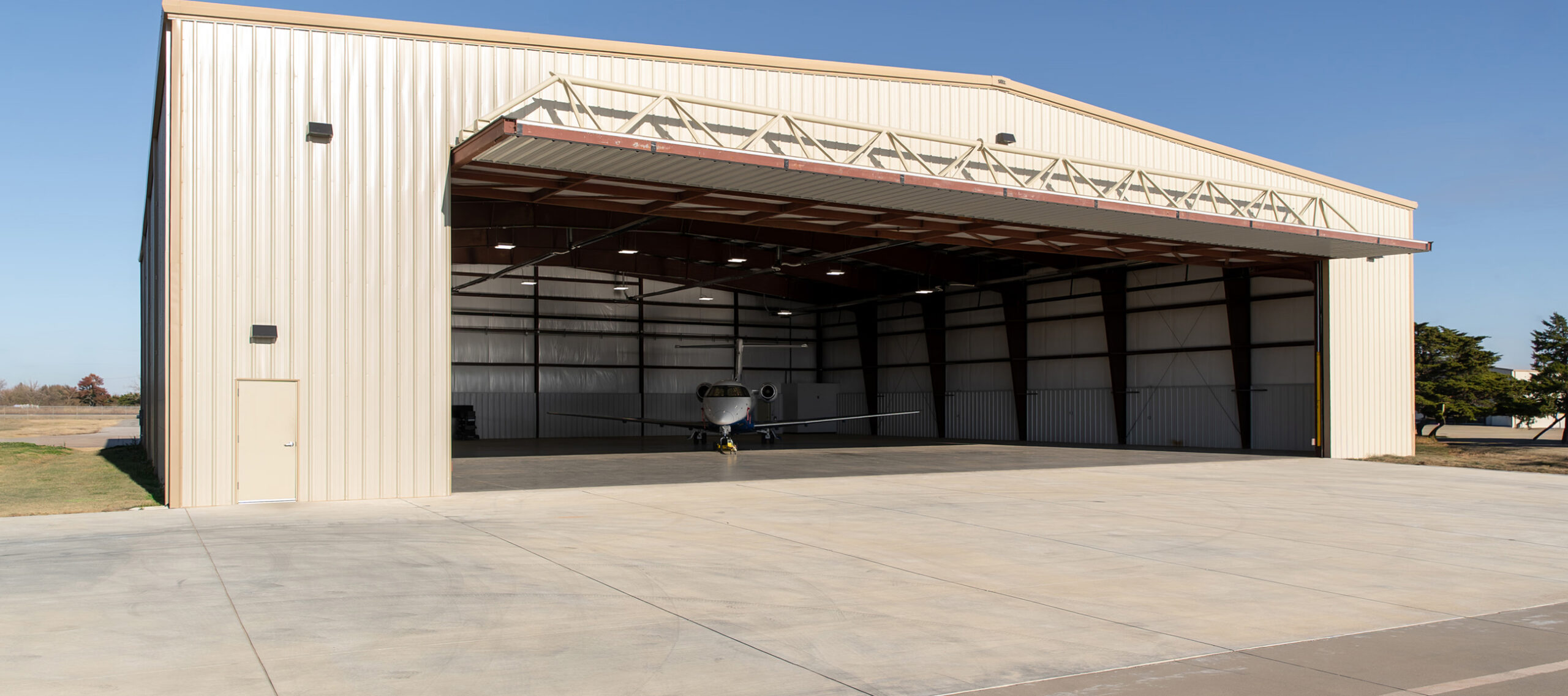 Private aircraft management company hangar with a private jet positioned inside, reflecting organized operations and aircraft readiness.