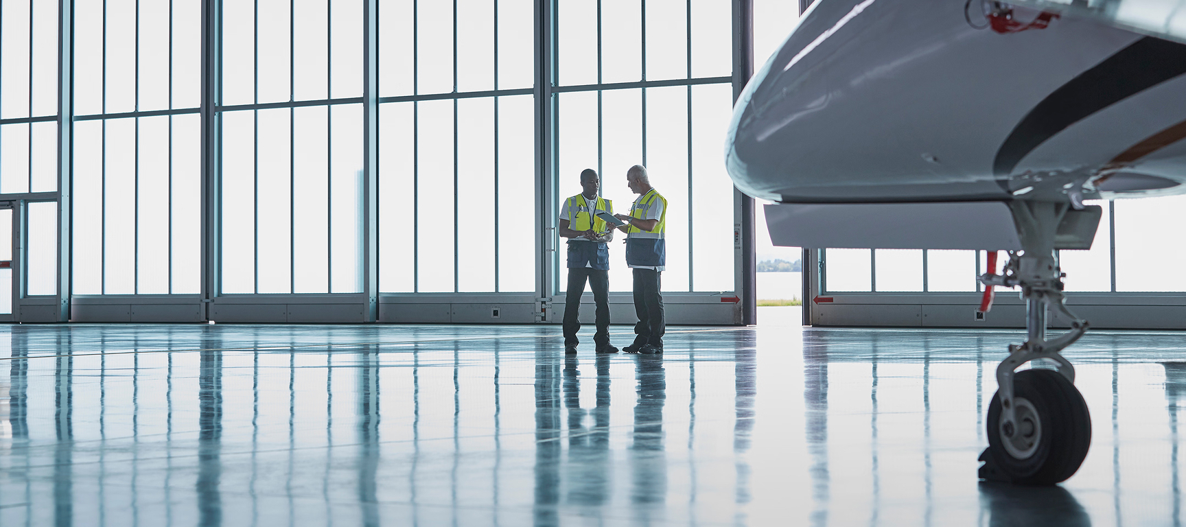 Aircraft management company maintenance team overseeing a maintenance inspection on a private jet inside a hangar, ensuring the aircraft is prepared, compliant, and ready for flight.