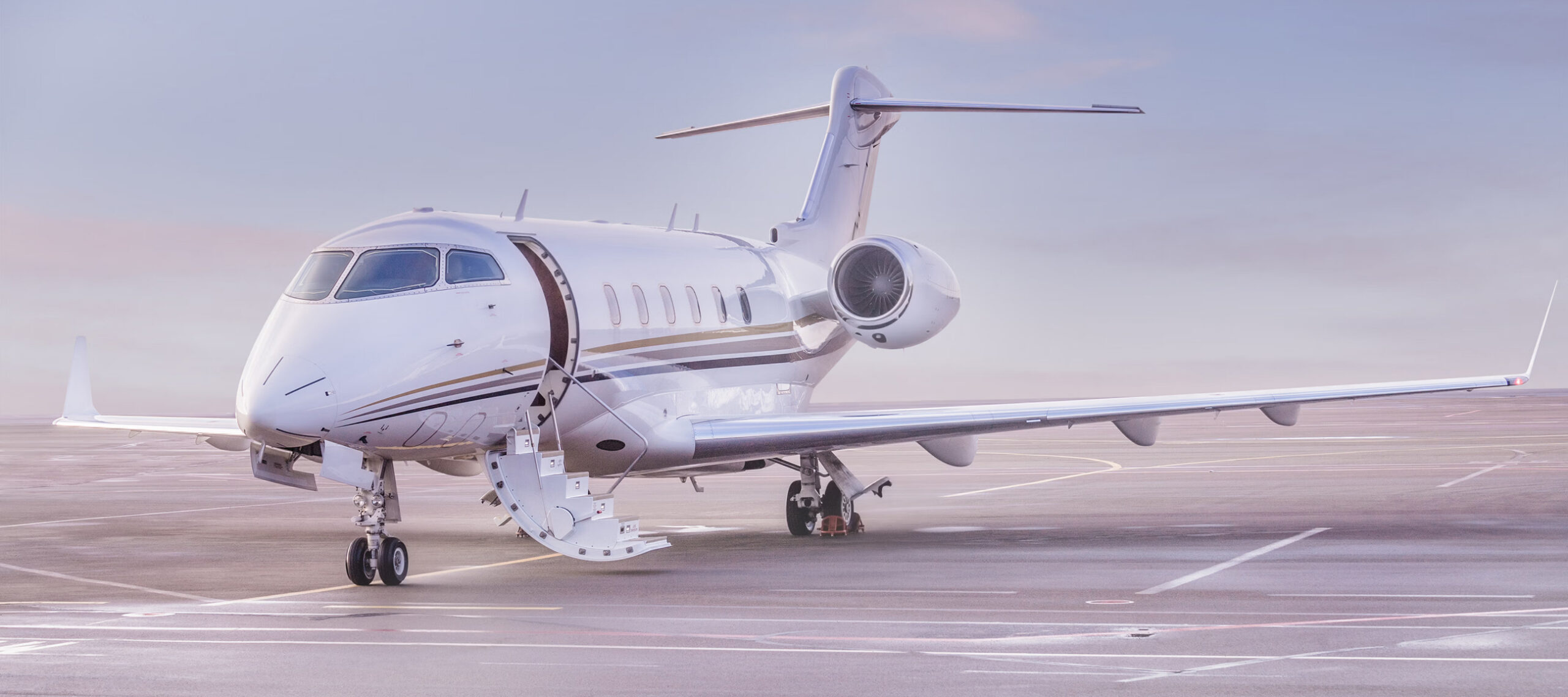 Private jet parked on an airport ramp with the cabin door open at dawn, representing private aircraft acquisition, aircraft brokerage, and ownership readiness before its first mission.