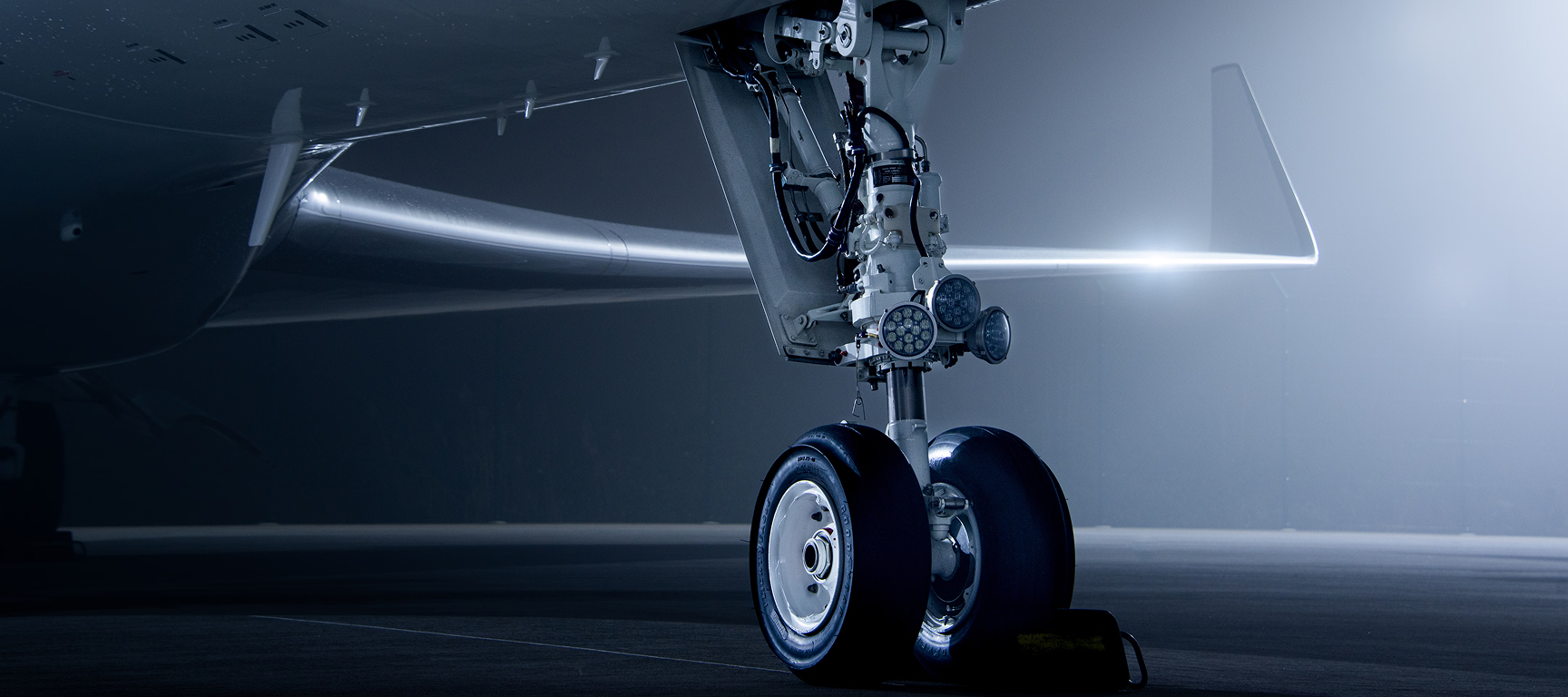 Close-up of a private jet landing gear during a pre-purchase inspection, highlighting the technical evaluation and attention to detail involved in private aircraft acquisition.
