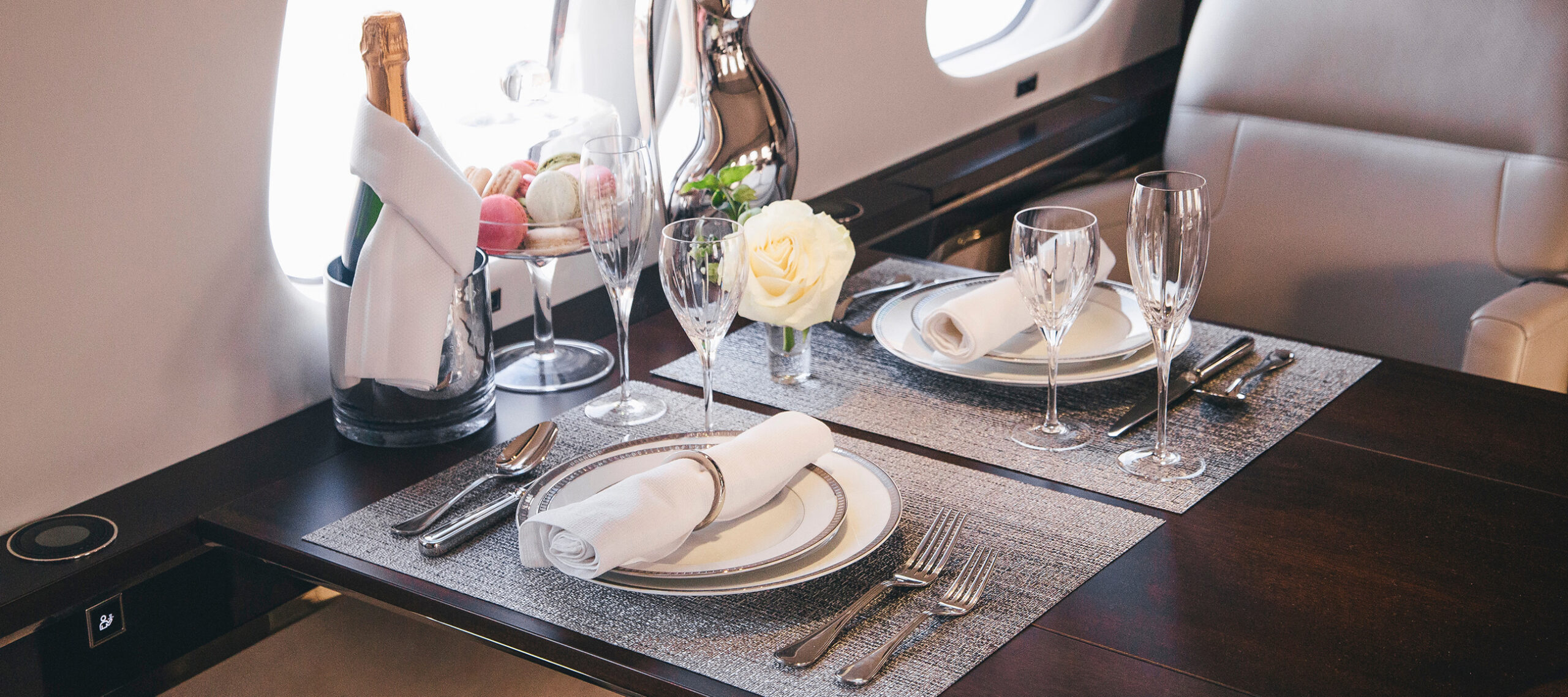 Luxury dining table prepared inside a private jet cabin, representing the personalized service, familiarity, and convenience of the FLYUSA private jet charter membership for frequent travelers.